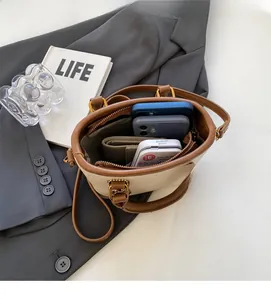 Vue intérieure du sac seau crème montrant la capacité pour téléphone et portefeuille
