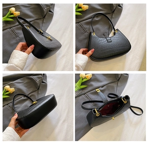 Détails du sac à main noir à motif crocodile avec finitions dorées et doublure rouge