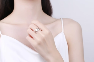 Close-up of elegant silver openwork ring with abstract design worn on model's index finger