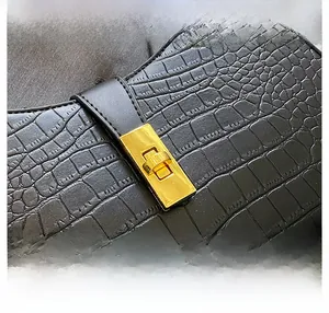 Gros plan sur le cuir noir effet croco avec fermoir rotatif rectangulaire doré chic
