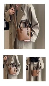 Détail d'un sac seau vintage marron avec breloque d'ours en métal et texture cuir
