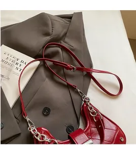 Detail of red quilted baguette bag with silver chain and adjustable shoulder strap