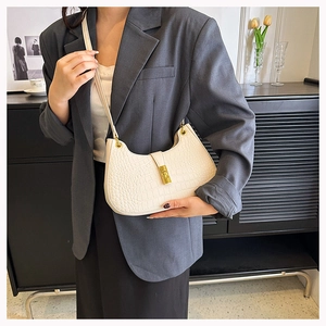 Détail du sac à bandoulière blanc à motif crocodile avec fermoir en métal doré