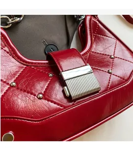 Detail of red dumpling bag featuring quilted leather texture and silver buckle