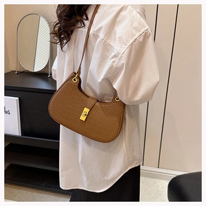 Détail du sac à bandoulière marron motif crocodile avec boucle dorée vintage