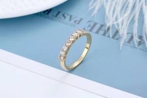 Dettaglio macro di un anello placcato oro con sette zirconi cubici rotondi incastonati