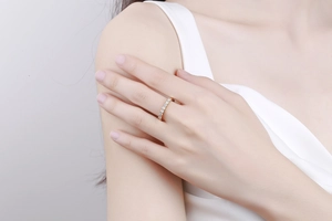 Primo piano di un anello eternity dorato con piccoli zirconi tondi sulla mano di una donna