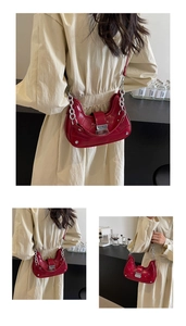 Detail of red quilted hobo bag with silver studs and metal chain shoulder strap