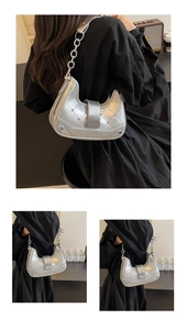 Detail of silver metallic dumpling bag with quilted texture, studs and chain strap