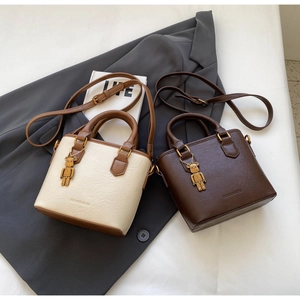 Détail de sacs seaux vintage en cuir PU avec pendentif ours en métal et textures fines