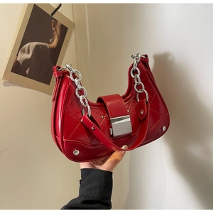 Detail of red quilted leather hobo bag with silver studs and chunky metal chain strap