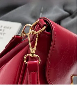 Macro shot of durable gold metal hook and glossy burgundy faux leather strap detail
