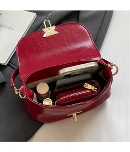 Detailed view of the spacious inner compartment and golden metal buckle of the red bag