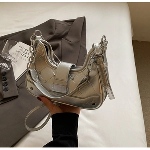 Silver quilted crescent bag with metallic finish, chain link strap and stud accents