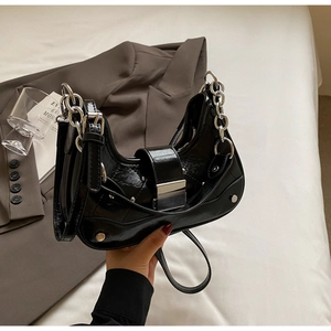 Detail of black wrinkled leather hobo bag with chunky silver chain and rivet accents