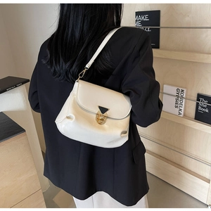Detail of a creamy white leather shoulder bag with a gold triangular metal buckle