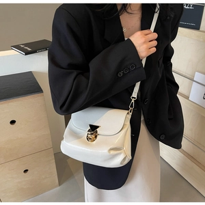 Detail of white pleated leather bag with gold triangle lock and slim shoulder strap