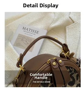 Detail showing comfortable reinforced leather handle and smooth double zipper closure