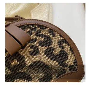 Detailed close-up of leopard print fabric textures and precision stitching on the handbag