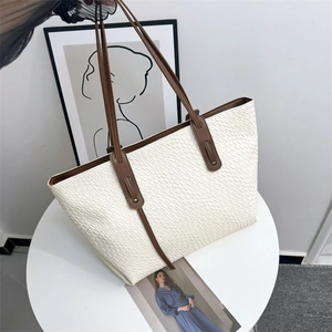 Large white woven tote bag with brown leather shoulder straps and vintage design style