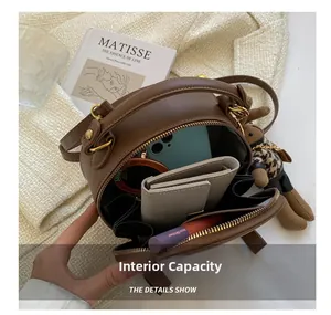 Internal capacity of the brown leather round bag showing multiple storage compartments