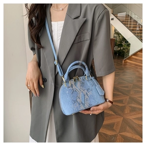 Vue détaillée du cuir de serpent bleu sur un sac à main avec des détails en métal doré