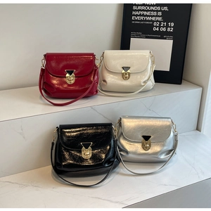 Close-up of glossy leather texture and golden twist lock on stylish flap handbags