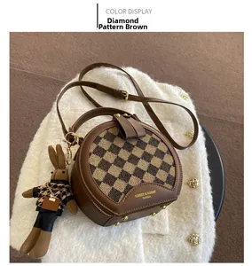Detail of round leopard print crossbody bag with cute rabbit charm and gold logo