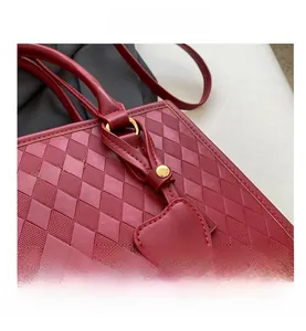 Détail de sac cabas matelassé bordeaux avec garniture dorée et pendentif en cœur