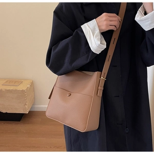 Braune Eimer-Tasche aus Leder mit Ziernähten am Modell für einen stilvollen Look