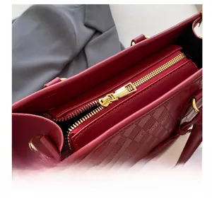 Vue détaillée du sac en cuir matelassé bordeaux avec fermeture éclair dorée élégante