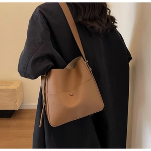 Detailansicht der braunen Beuteltasche aus genarbtem Leder mit Druckknopf-Vordertasche