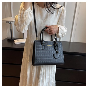 Détail du sac cabas matelassé noir avec pendentif coeur et texte FASHION & BAGS