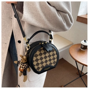 Detail of round checkered crossbody bag with leopard bunny charm and gold hardware