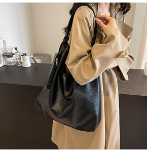 Gros plan du sac cabas en cuir noir avec fermeture éclair latérale et doubles anses