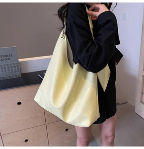 Détail du cabas en cuir jaune citron montrant la texture grainée et la bandoulière
