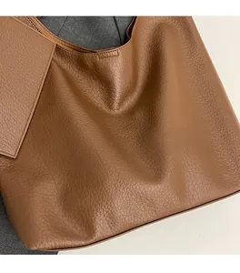 Vue détaillée de la texture du cuir marron grainé sur le grand sac cabas pour femme