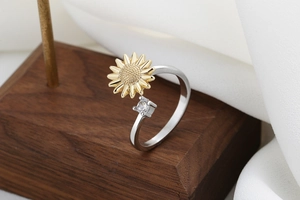 Detailed shot of two-tone sunflower ring with sparkling square zircon on wood surface