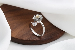 Detailed shot of a spinning sunflower ring with gold stamens and a zircon stone detail