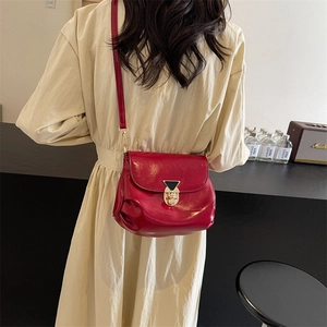 Chic red glossy underarm bag with pleated design and gold buckle shown on model