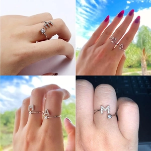 Dettaglio di anelli aperti in argento con zircone e lettere M e A tempestate di cristalli
