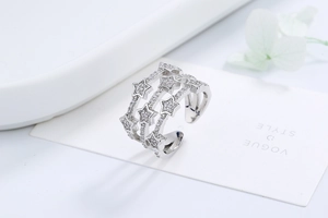 Detail of multi-layer silver star ring with shimmering pave crystals on white background