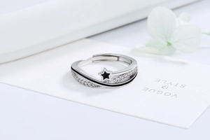 Close-up of silver star ring with black enamel lines and sparkling zircon stones
