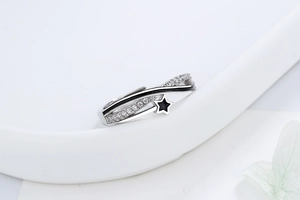 Detail of adjustable star ring with black enamel and sparkling white zircon stones