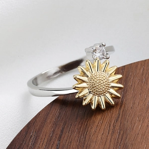 Sunflower spinning ring in silver and gold plating with zircon stone on wooden display