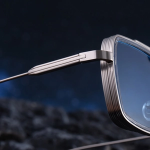 Detailed macro view of the silver metal frame hinge and ribbed texture on square sunglasses