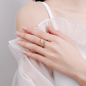 Adjustable sunflower spinner ring with gold petals and silver band on female model
