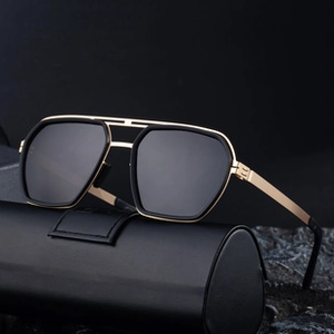 Close-up of irregular black lenses with golden double bridge and slim metal temples
