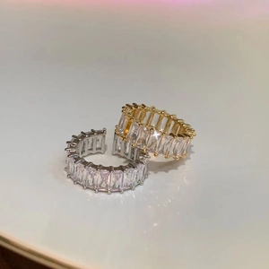 Gros plan de bagues d'éternité or et argent avec zircons taille émeraude en cercle