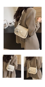 Detail of cream saddle bag featuring pebble leather texture and pearl heart charm